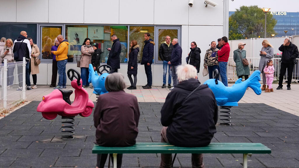 People wait in line outside a polling station before the start of the voting in a parliamentary election in Belgrade, Serbia, Sunday, Oct. 25, 2026.